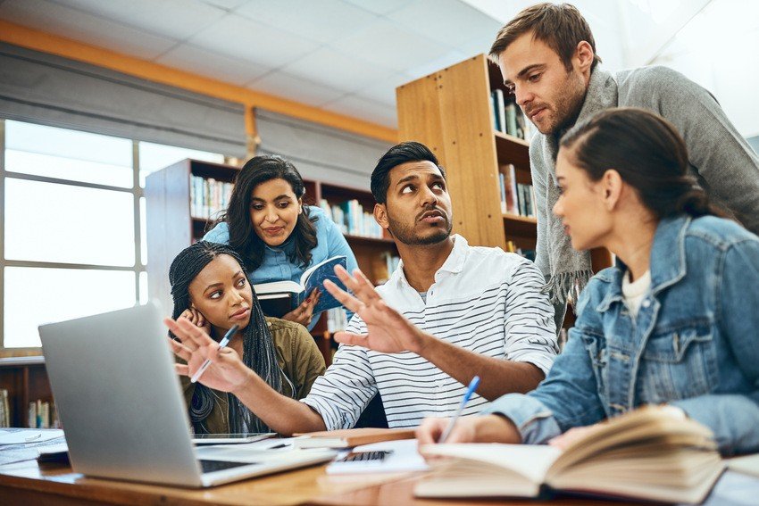 A group of students in a library looking at a laptop while preparing for the MCCQE1 exam using Ace QBank.