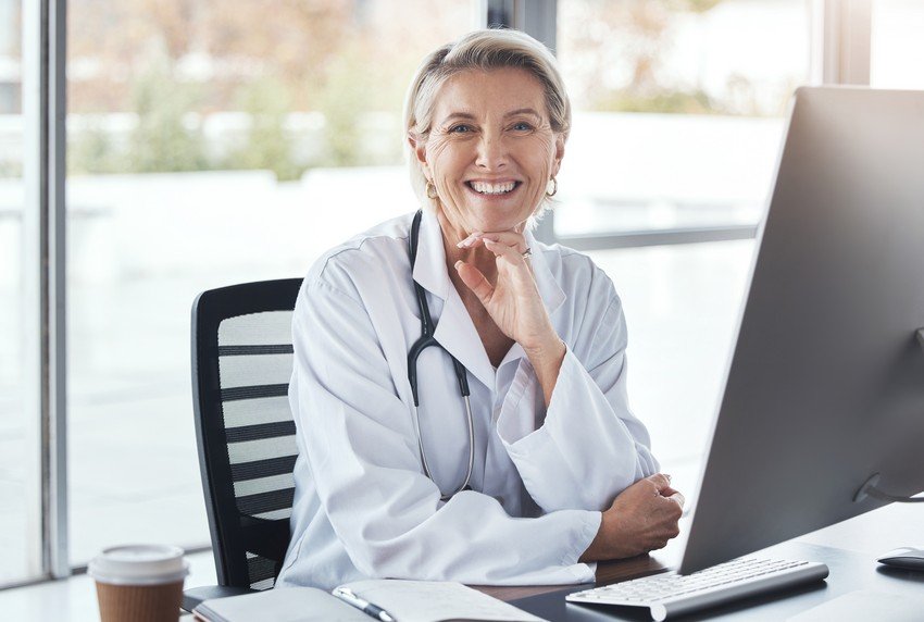 A female doctor editing content for the MCCQE1 exam is sitting in front of a computer.