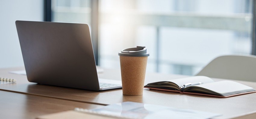 A laptop on a desk next to a cup of coffee from a candidate getting ready for MCCQE1.