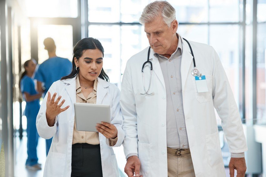 A doctor and resident are browsing a question bank on a tablet screen for MCCQE Part 1 exam preparation.