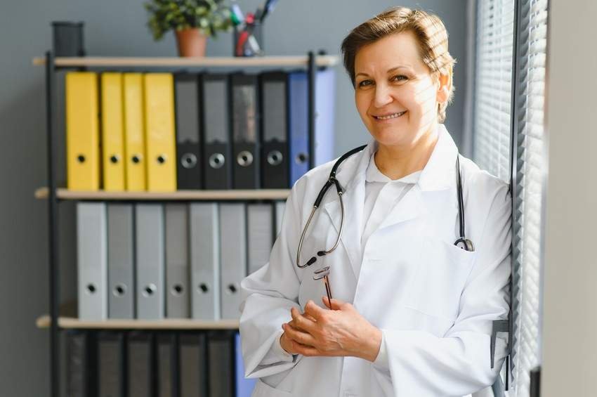 Confident healthcare professional with a stethoscope stands in an office, talking about ultimate qbank for the MCCQE1 and PLAB exam.