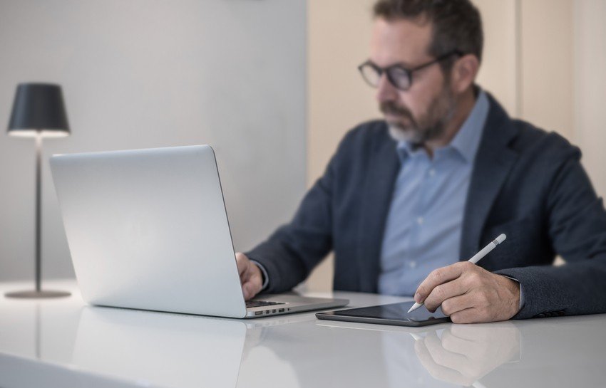 A man using a laptop and a stylus to access Ace QBank online question bank, perfect for preparing for the MCCQE1 exam.