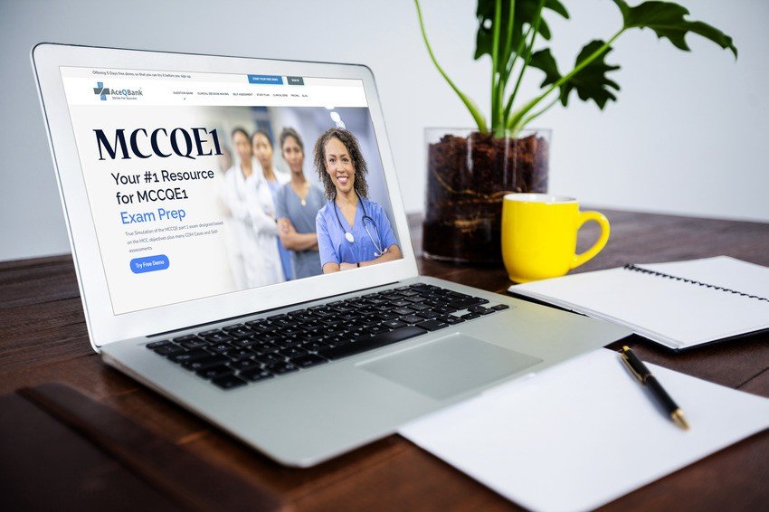 A laptop on the table displays a website with medical professionals and the text "Ace QBank: Your #1 Resource for MCCQE1 Exam Prep." Nearby sit a notebook, pen, yellow mug, and potted plant—everything you need for effective MCCQE1 prep.