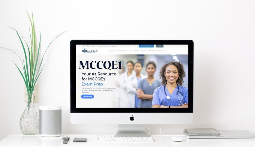 An iMac on a white desk displays the Ace QBank website for MCCQE1 exam preparation, featuring a group of healthcare professionals on the screen.