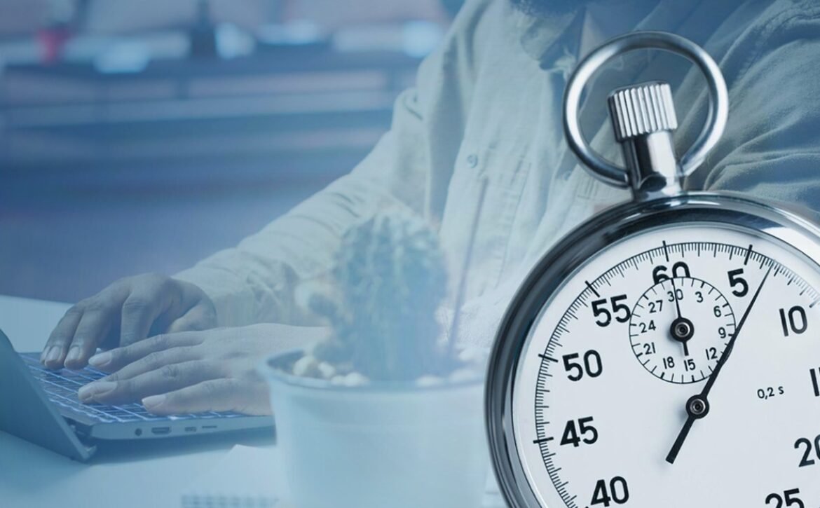 A person types on a laptop at a desk with a small potted plant, while a large stopwatch shows roughly 22 seconds. capturing the focus and efficiency needed for MCCQE1 exam preparation with Ace QBank.