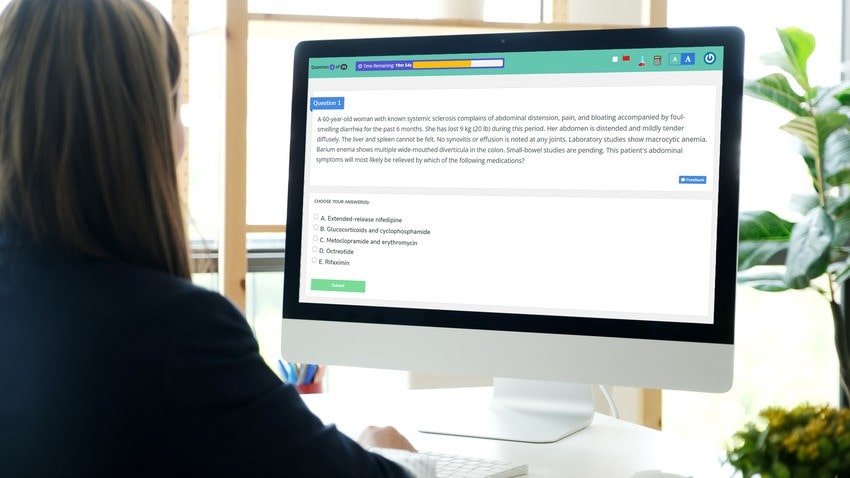 A person sitting at a desk looks at a computer screen displaying a multiple-choice medical question, staying motivated while following their MCCQE1 study plan with Ace QBank for the MCCQE1 exam preparation.